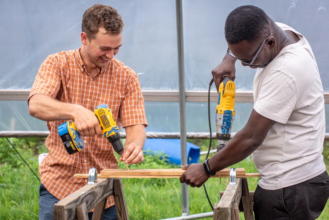 Two people practice safe use of hand tools on an urban farm in Baltimore, MD