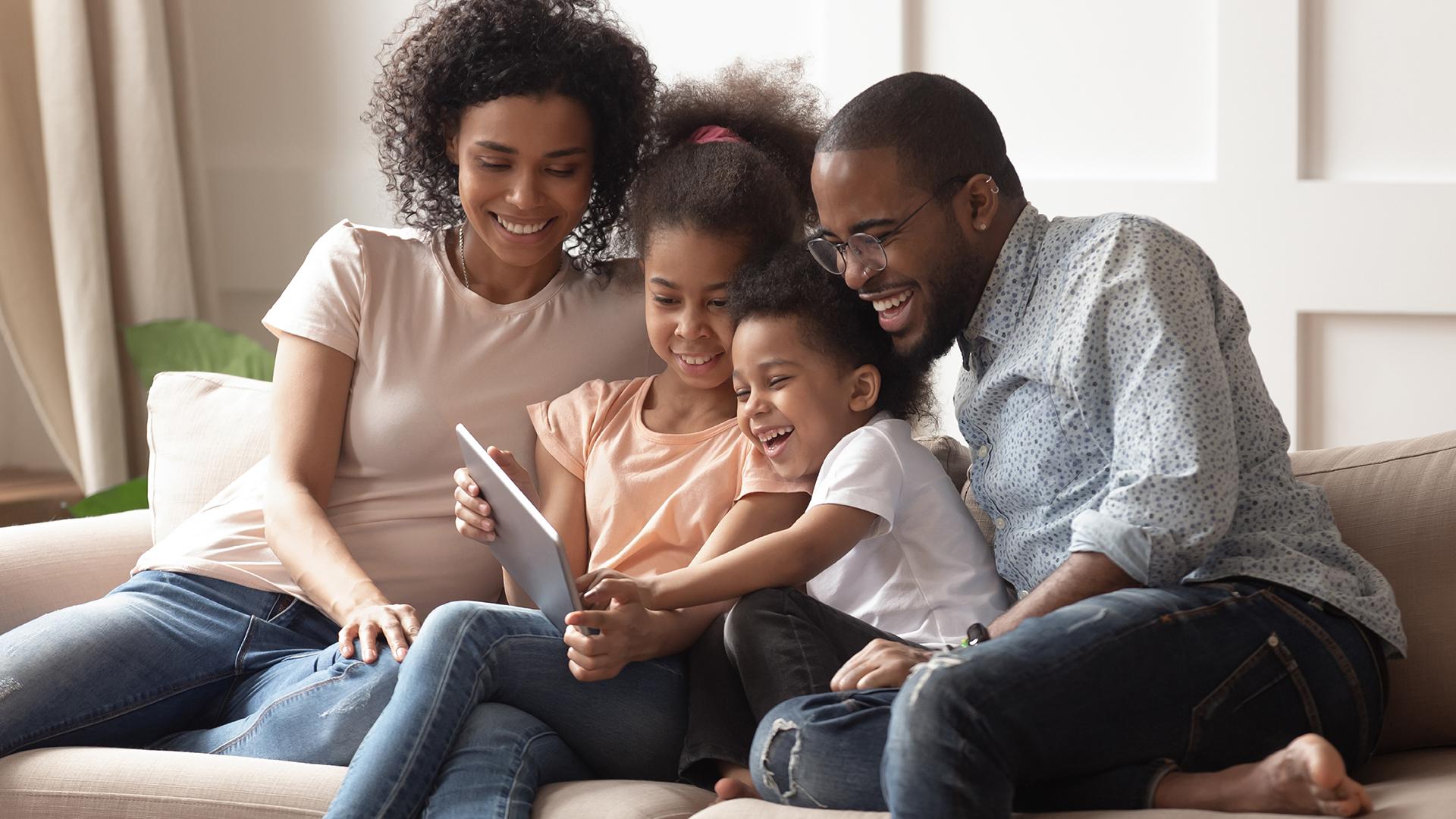 Family looking at a computer on the sofa