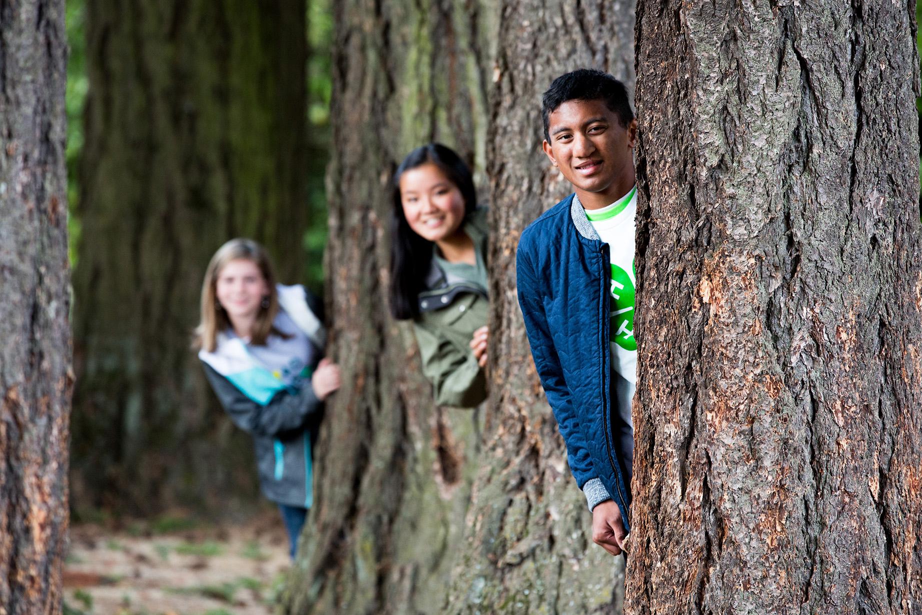 youth behind tree