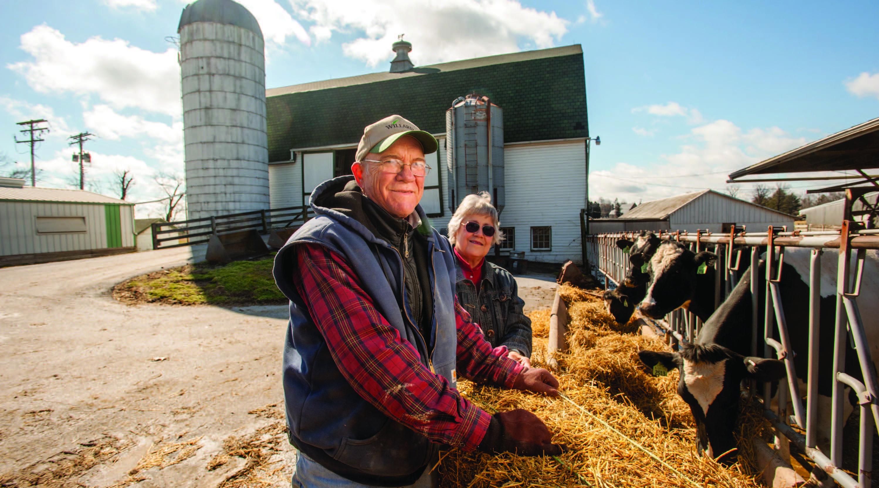 Farm couple posing in farm yard.