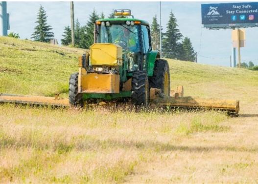 Fig. 1. Transportation maintenance specialist mowing an interstate roadside. Photo: Oregon Department of Transportation (CC).