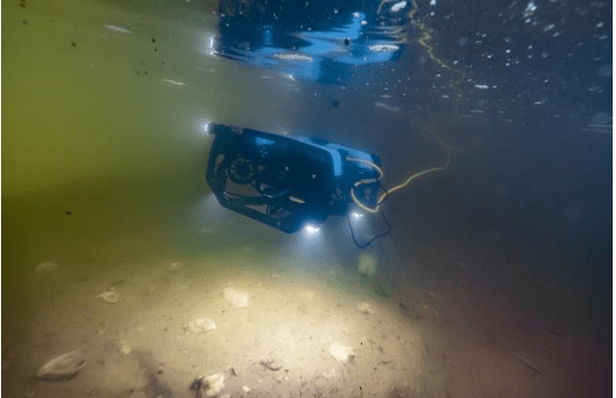 An underwater drone spotlights oyster shells in a tank at the Horn Point laboratory of the University of Maryland Center for Environmental Science. Through the use of “machine learning,” researchers hope to get the device to “see” through murky Bay water to identify live oysters on the bottom and find favorable spots to plant more.