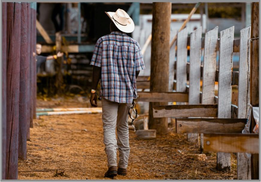 Cowboy walking in a barn